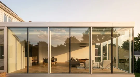 Wide-angle view of a modern glass extension with visible HVAC system components